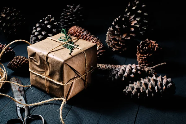 Caja Regalo Envuelta Papel Kraft Tijeras Cuerda Piñas Sobre Madera — Foto de Stock