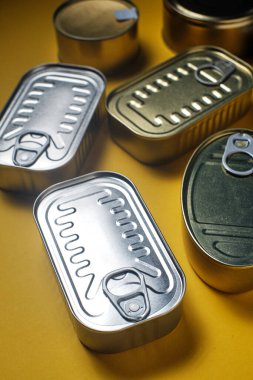 Sarı arka planda kapalı teneke kutular, yukarıdan görülüyor