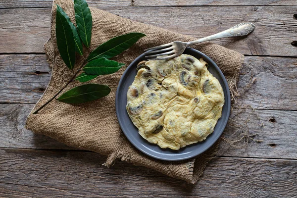 Çuval bezi ve kırsal masada mantarlı omlet.
