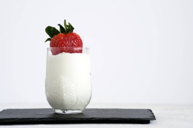 Sütlü tatlı. Bardakta taze çilekli yoğurt.