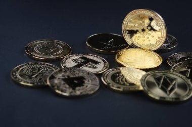 Cardano kripto para birimini vurgulayan, siyah arkaplanı olan çeşitli altın kriptolar..