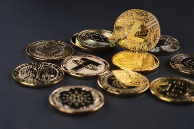Kripto para birimi Litecoin 'i vurgulayan, siyah arka planlı çeşitli altın kripto para birimleri.