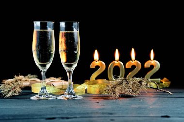 2022 yılına ait iki kadeh şampanya ve mum.