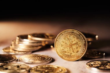 Xrp ile birlikte bir kripto para koleksiyonu gösterilir. Paralardan yansıyan ışık, detaylı yüzeylerini vurguluyor..