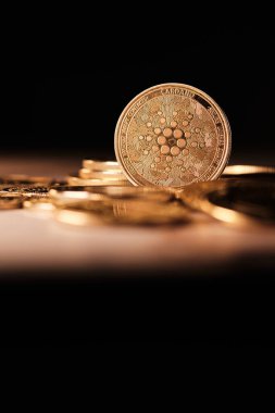 Cardano 'nun önemli rol oynadığı bir kripto para koleksiyonu sergilenmektedir. Paralardan yansıyan ışık, detaylı yüzeylerini vurguluyor..
