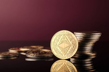 Ethereum kripto paralar parlak bir yüzeye yerleştirilir. Bazı paralar istiflenirken diğerleri dağınıktır. Işıklandırma madeni para tasarımı ve ayrıntıları vurgular.