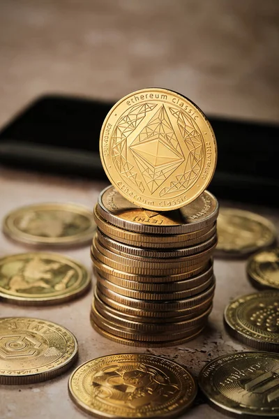 Bir masaya çoklu altın sikke konur. Üzerinde Ethereum tasarımı olan bir madeni para öne çıkıyor. Sikkeler ışığı yansıtır ve parlak bir görünüm yaratır..