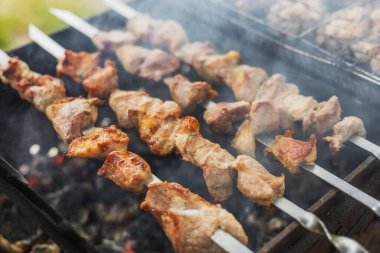 Domuz eti parçaları mangal kömürü üzerine şişte kızartılıyor.