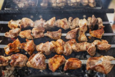 Domuz eti parçaları mangal kömürü üzerine şişte kızartılıyor.