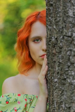 Ormanda kameraya bakan güzel genç bir kadın. Yaz günü