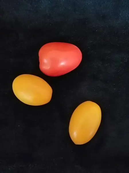 Siyah arka planda, taze domatesler, sarı ve kırmızı, üst manzara, izole, yakın çekim.