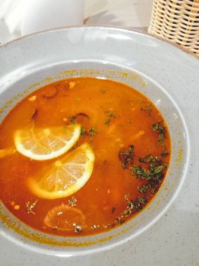 Büyük limon dilimli bir tabakta solynka çorbası.. 