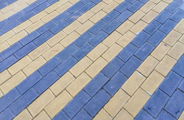 Tuğla döşeme levhalarının arka planı çapraz olarak iki renk, mavi ve açık sarı.