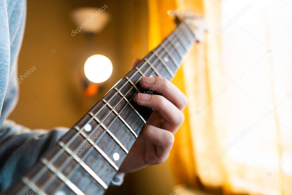 Guitarist plays the guitar. Focus on hands.Young man playing electric guitar