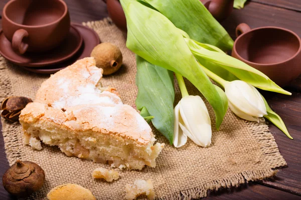 Stück Kuchen, Tee und Blumen auf einer Serviette aus einem Sack — Stockfoto