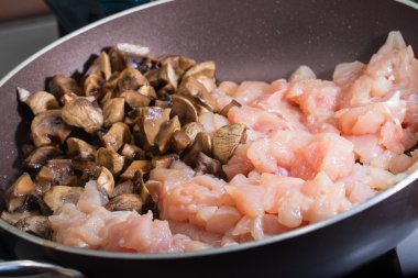 Ham tavuk eti ve mantar bir tava üzerinde