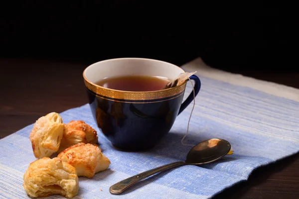 Cup of tea with a bag of tea leaves and home-made cookies — Stock Photo, Image