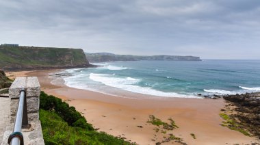 View of the sandy beach in cloudy foggy day clipart