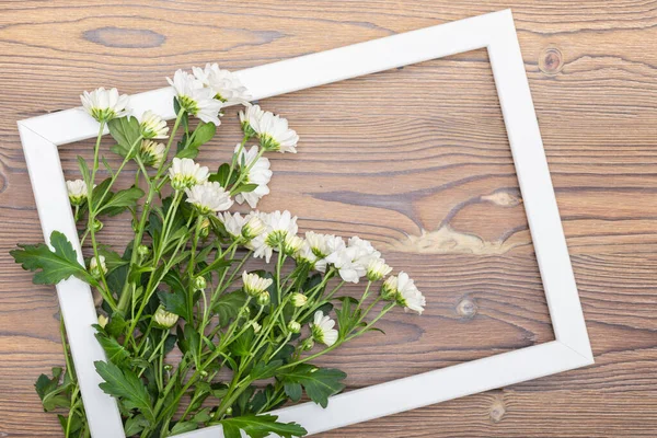 The frame with empty space inside rests on a wooden table. — Stock Photo, Image