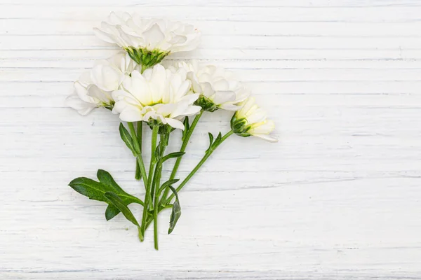 A bouquet of white bush chrysanthemums on a wooden table. — Stock Photo, Image