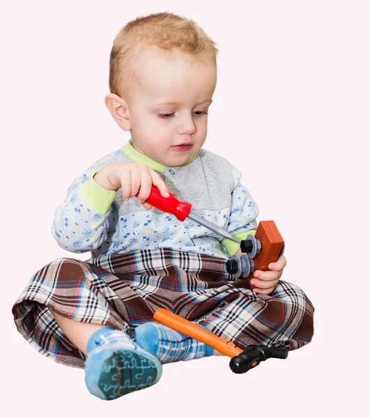 O menino brinca com uma chave de fenda de plástico, um martelo e s — Fotografia de Stock