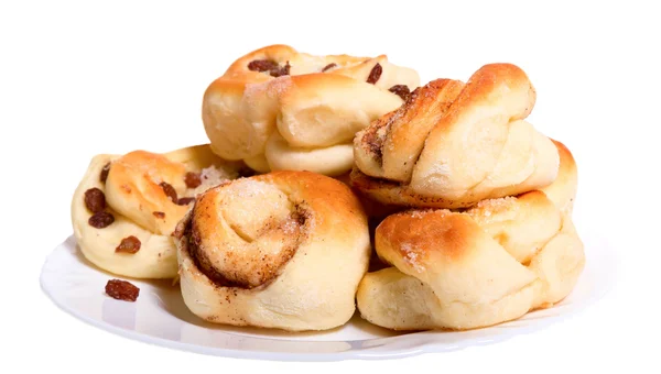 Goldene Röstbrötchen mit Rosinen auf weißem Teller. — Stockfoto