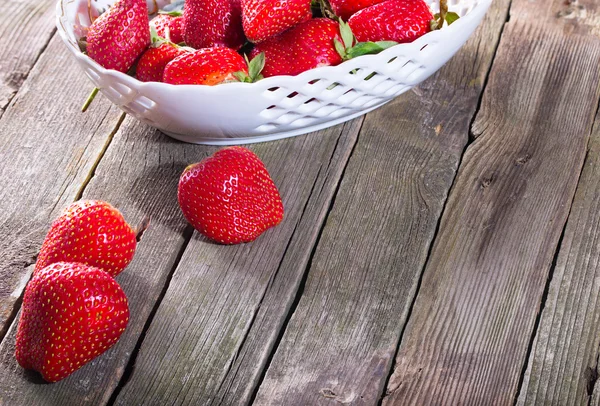 Parte de un plato con fresa y algunas bayas rojas caídas en ol — Foto de Stock