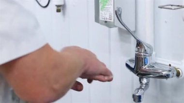 Üretim işçisi ellerini iyice yıkar. 50 peni.