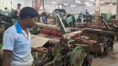Jute, Bangladeş 'in doğal altın elyafıdır. Jute Mills fabrikasının içinde işçiler Bangladeş Jute Mills fabrikasında sağlık riskiyle uğraşıyorlar..