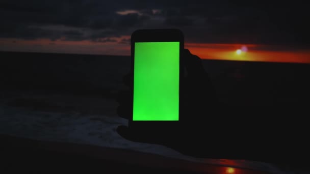 Άντρας κρατώντας στο smartphone στο ηλιοβασίλεμα. — Αρχείο Βίντεο