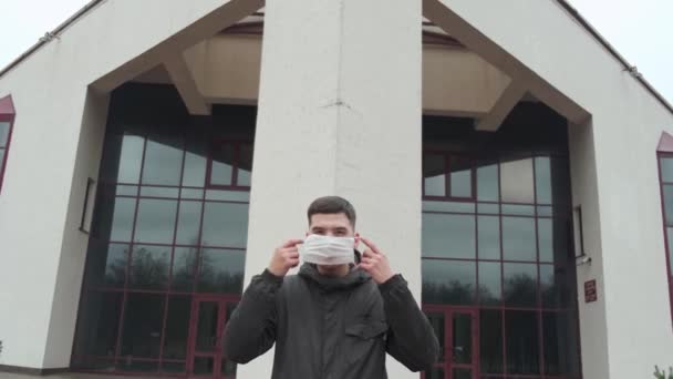 4K顔マスクを身に着けている若い男外でコロナウイルスCOVID-19流行 — ストック動画