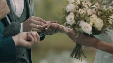 Damat gelinle evlilik yüzüğünü değiş tokuş ediyor.