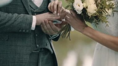 Damat gelinle evlilik yüzüğünü değiş tokuş ediyor.
