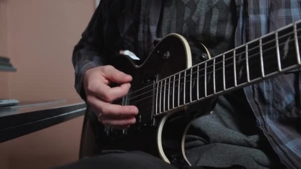 Gros plan de la main masculine jouant de la guitare électrique. — Video