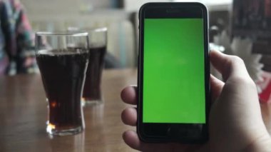Krom anahtar ya da yeşil ekran Erkek ellerindeki siyah akıllı telefonlarda