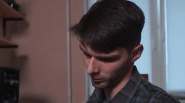 Ses stüdyosu kaydı. Adam müzik stüdyosunda şarkı söylemeden önce kulaklık takıyor..