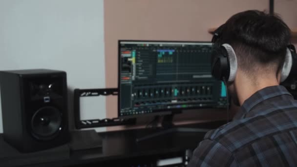 O músico trabalha em um computador e cria uma composição musical. — Vídeo de Stock