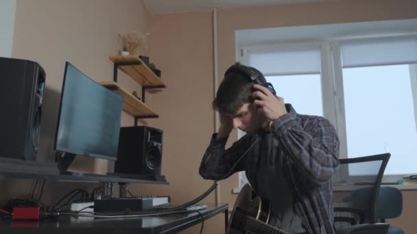 Gitaris tampan dengan jenggot memainkan gitar akustik di studio musik. Penutup — Stok Video