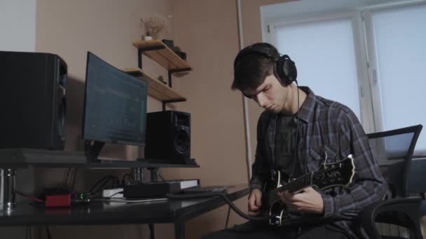 Guitarrista guapo con barba toca guitarra acústica en un estudio de música. Primer plano. — Vídeo de stock