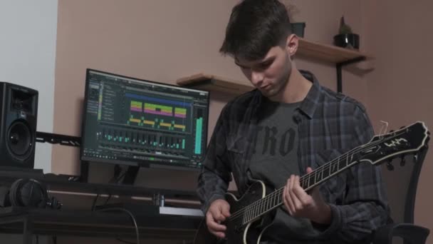 Il musicista lavora su un computer e crea una composizione musicale. — Video Stock