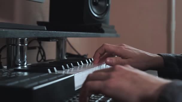 Manliga händer spelar elektroniskt tangentbord, midi nycklar på bordet. — Stockvideo