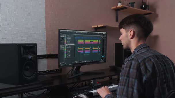 Hudebník pracuje na počítači a vytváří hudební kompozici. — Stock video