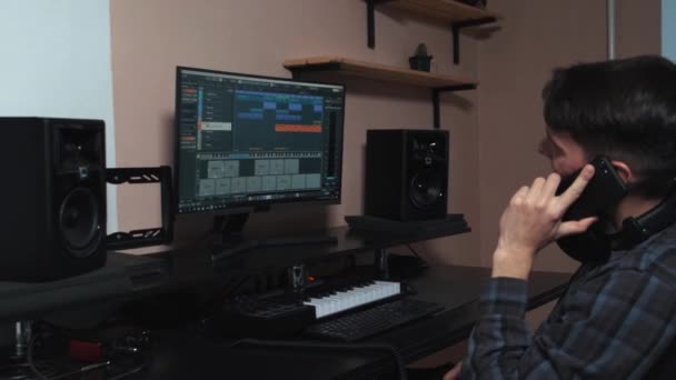 The musician works on a computer and creates a musical composition. — Vídeo de stock