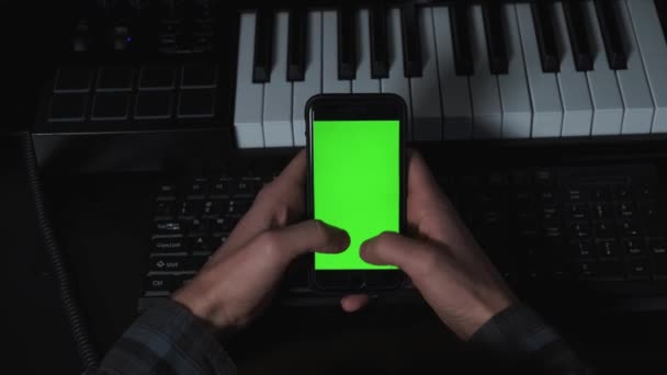 Close up shot of guy in music studio using phone with green screen — Vídeo de stock