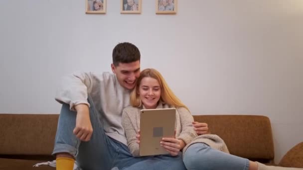 Joven hombre y mujer relajarse con su tableta. Resolución 4k. — Vídeos de Stock