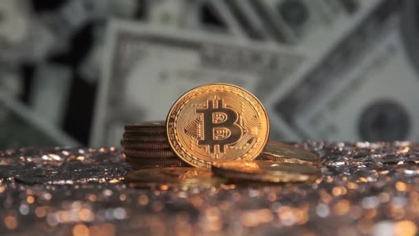 Un primo piano di bitcoin brilla in oro su uno sfondo di dollari in caduta. — Video Stock