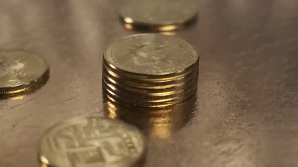 Le monete Bitcoin ruotano da vicino su un tavolo d'oro. — Video Stock