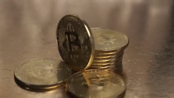 Bitcoin monety są zbliżenie obracające się na złotym stole. — Wideo stockowe