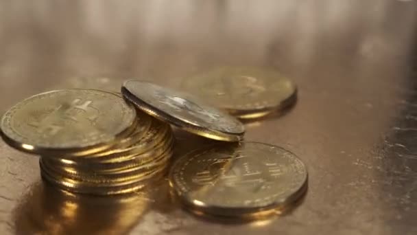 Bitcoin pièces sont en gros plan tournant sur une table d'or. — Video