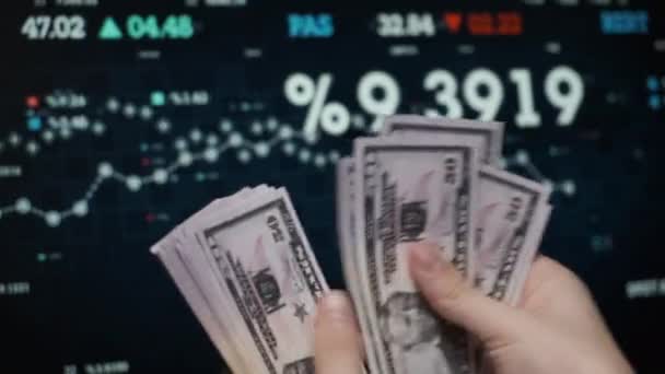 De belegger telt het geld tegen de achtergrond van de aandelen. — Stockvideo